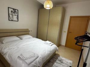 a bedroom with a bed with white sheets and a closet at Maren apartment in Orikum +13 photos