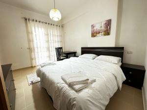 a bedroom with a large white bed with towels on it at Maren apartment in Orikum