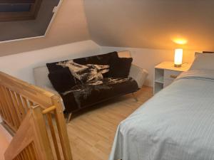 a living room with a couch next to a bed at Strandhaus in der Düne in Dierhagen