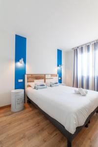 a bedroom with a large white bed with blue walls at Cit'Hotel Imperial in Sète