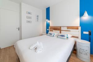 a bedroom with a white bed with towels on it at Cit'Hotel Imperial in Sète
