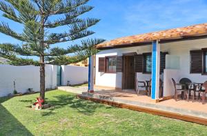 una casa con un pino en el patio en Bungalow Ramos, en Conil de la Frontera
