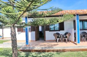 una casa con una mesa y sillas en un patio en Bungalow Ramos, en Conil de la Frontera