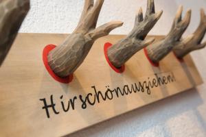 een houten bord met hertenhoorns aan de muur bij Hotel Filser in Füssen
