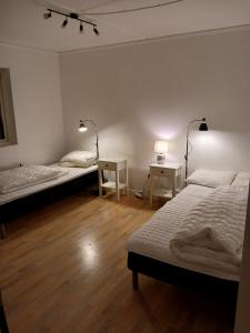 a room with two beds and a table and two lamps at 3 rum och kök 3 bäddar in Ruda