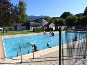 een groep mensen die zwemmen in een zwembad bij Camping Le Saillet in Lestelle-Bétharram