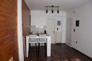 a kitchen with a counter and two stools at Balkanisateur Studio A in Kavala