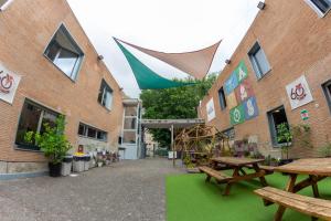 un patio con mesas de picnic frente a un edificio en Scout Madrid Hostel, en Madrid
