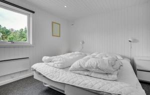 a white bedroom with a bed with a window at Pool activity house for 14 people in Marielyst +32 photos