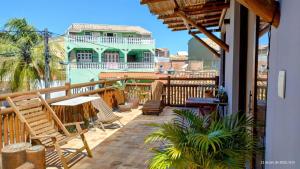 een balkon met stoelen en een huis op de achtergrond bij Casa Dendê Praia do Forte in Praia do Forte