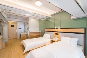 Llit o llits en una habitació de Dequan Hotel Chaoyang Park Branch Coffee fruits, snacks a gym and a laundry room are provided for free in the lobby