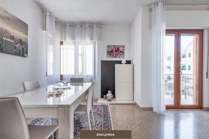 a white kitchen with a table and a refrigerator at Di Palma 4 Family House - Lecce Selection in Lecce