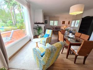 a living room with chairs and a table and a dining room at Villa Serena - Casa rural en Arcos con piscina, barbacoa, chimenea in Arcos de la Frontera