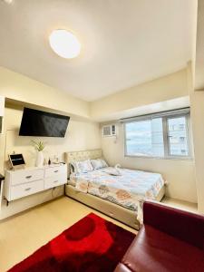 une chambre avec un lit et une télévision à écran plat dans l'établissement Avida Towers near Marco Polo And Roxas Market, à Davao