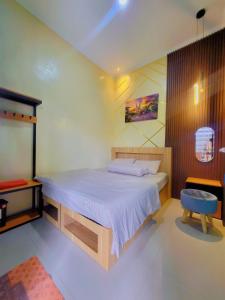 a bedroom with a bed and a blue chair at Adyvan Villa in Malang