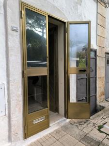 an open glass door of a building at by Domy in Ostuni
