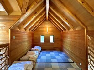 una stanza con tre letti in mansarda di MARUTA 和歌山すさみ a Susami