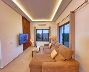a living room with a couch and a tv at Villa soléa - Route Ouarzazate in Marrakesh