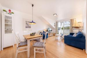 a living room with a table and a blue couch at Ferienwohnung Möwennest in Juliusruh