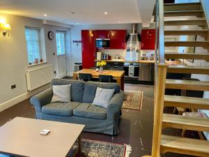 a living room with a blue couch and a kitchen at Menai Bridge in Menai Bridge