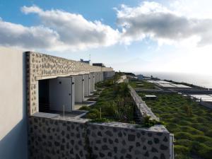 a building on a hill with the ocean in the background at BANCAL HOTEL and SPA in San Sebastián de la Gomera