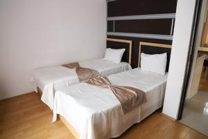 two beds in a room with white sheets at Arena Hotel Qakh in Qax +9 photos
