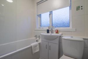 Un baño con lavabo, inodoro y ventana. en Boswell House - Modern 3 Bed House East Kilbride Close to Motorway, en East Kilbride 27 fotos más