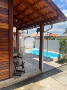 einem Holzpavillon mit einem Stuhl neben einem Pool in der Unterkunft Casa do Kélvio in Penha
