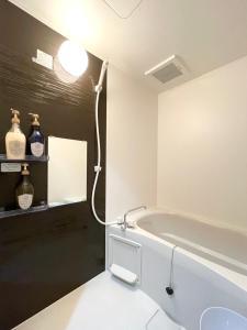 a bathroom with a bath tub and a sink at 蒼空Inn in Osaka +31 photos