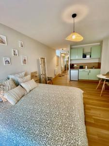 a bedroom with a large bed and a kitchen at L entre deux in Sangatte