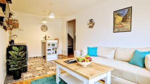 een woonkamer met een witte bank en een tafel bij Blue Lagoon 150m-2 minuta hoda od centra, mogucnost za parking-apartmani-nsmilos in Novi Sad