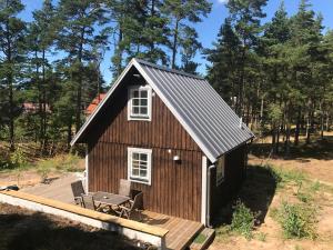 a small cabin with a deck and a table at Fårö house in Fårö