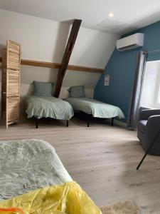 two beds in a room with blue walls at Le petit refuge in Saint-Béron