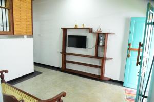 a living room with a tv and a couch at Captains Cabin Hikkaduwa in Hikkaduwa