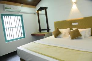 a bedroom with a large bed with a window at Captains Cabin Hikkaduwa in Hikkaduwa