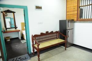 a room with a bench next to a refrigerator at Captains Cabin Hikkaduwa in Hikkaduwa