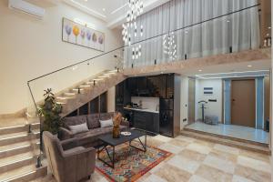 a living room with a couch and a staircase at Parliament Palace Hotel in Khujand
