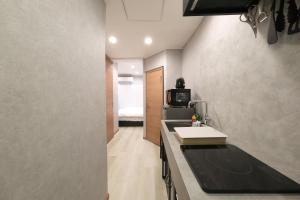 a small kitchen with a sink and a microwave at Ōizumigakuen House -大泉学園ハウス- 池袋まで15分 高速Wi-Fi アニメの聖地 in Yagisawa