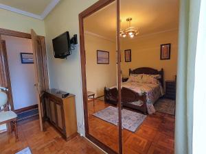a bedroom with a bed and a mirror at El Pescador in Ribadesella