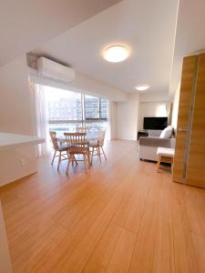 a living room with a table and chairs and a couch at Shinkou House UE - Newly Built Secure and Hypoallergenic in Osaka