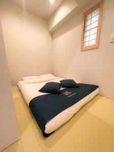 a bedroom with a large bed with two pillows on it at Shinkou House UE - Newly Built Secure and Hypoallergenic in Osaka