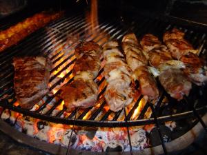 a bunch of meat cooking on a grill at RosenSuite SGH in Sangerhausen