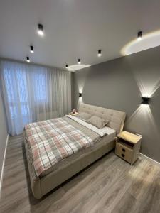 a bedroom with a large bed and a night stand at Buiucani Residence in Chişinău +39 photos