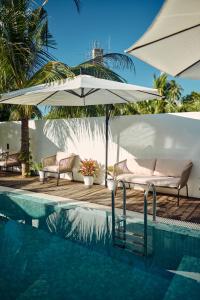 a pool with two chairs and an umbrella next to a pool at Kondey Villas in Kondey