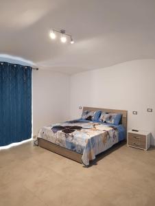 Un dormitorio con una cama en una habitación blanca. en C'est La Vie, en Caserta