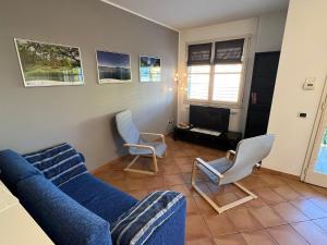 ein Wohnzimmer mit einem blauen Sofa und 2 Stühlen in der Unterkunft Giotto in Verbania