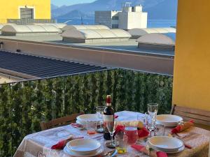 ein Tisch mit einer Flasche Wein und Gläsern auf einem Balkon in der Unterkunft Giotto in Verbania