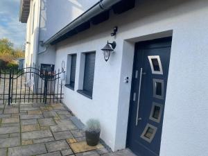 a white house with a blue door and a potted plant at Schäferstr 43 in Peine