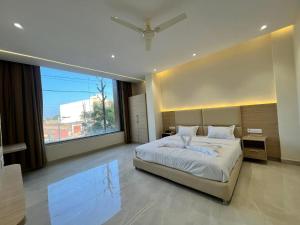 a bedroom with a large bed and a large window at Hotel The Lotus in Jhānsi
