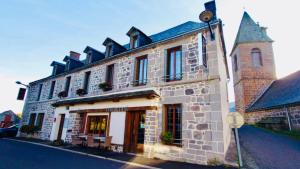 ミュラにあるHôtel Restaurant du Plomb du Cantalの通路脇の大きな石造りの建物